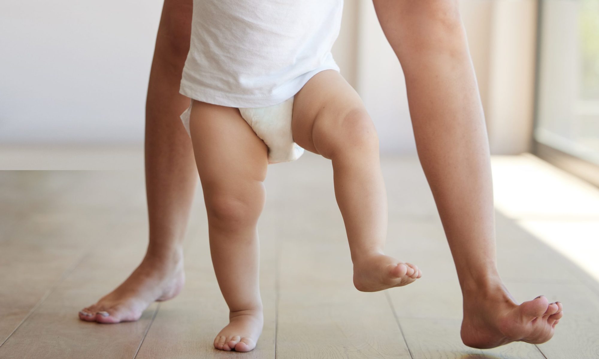 Baby, learning and walking with a child taking its first steps with his mother to learn to walk at .