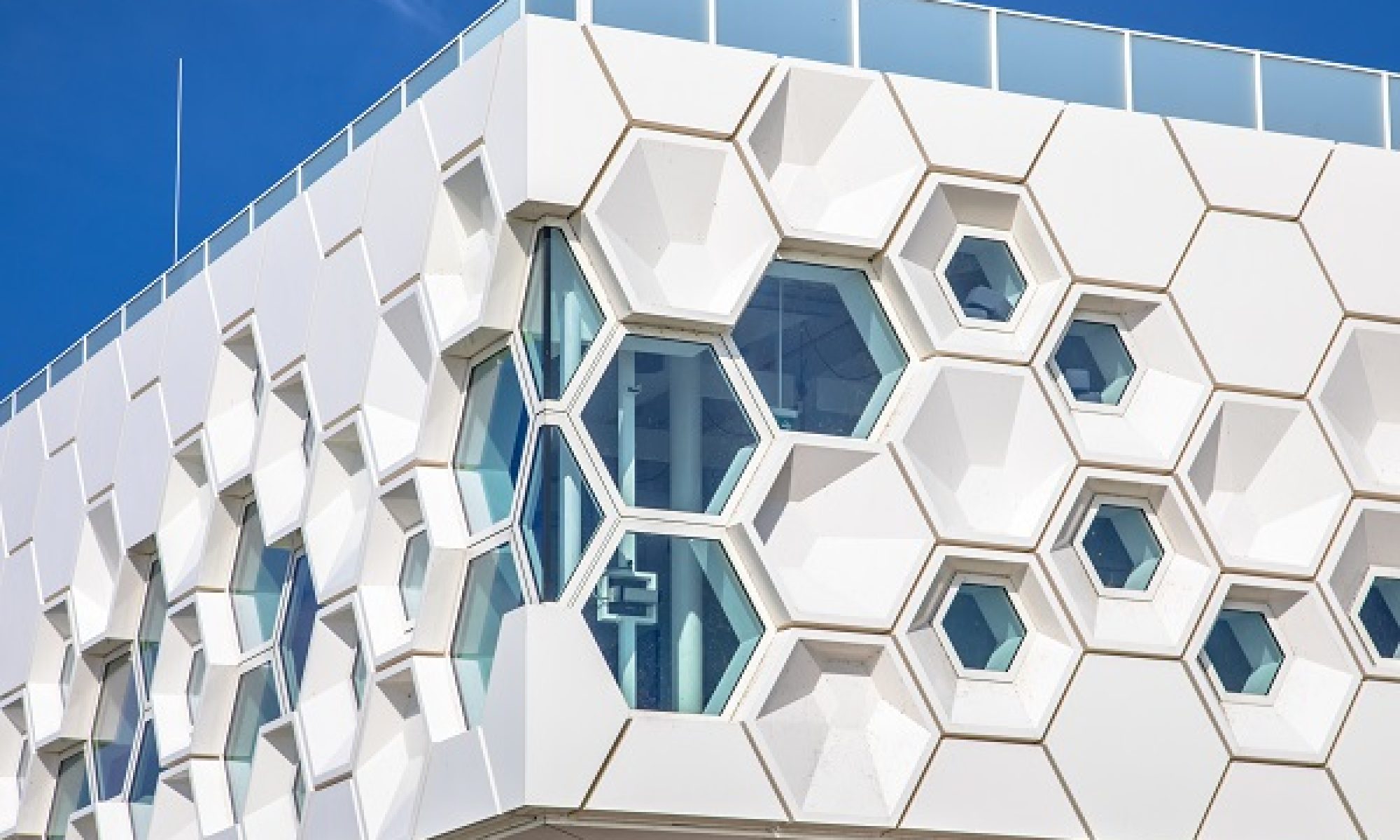 Closeup of modern facade of geometric architecture building in the Netherlands against blue sky.